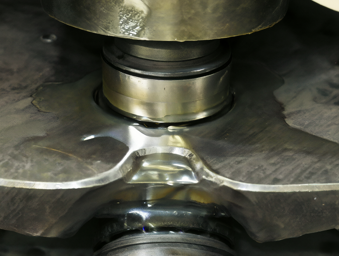 A detailed view of a greased central bearing supporting a massive steel structure.
