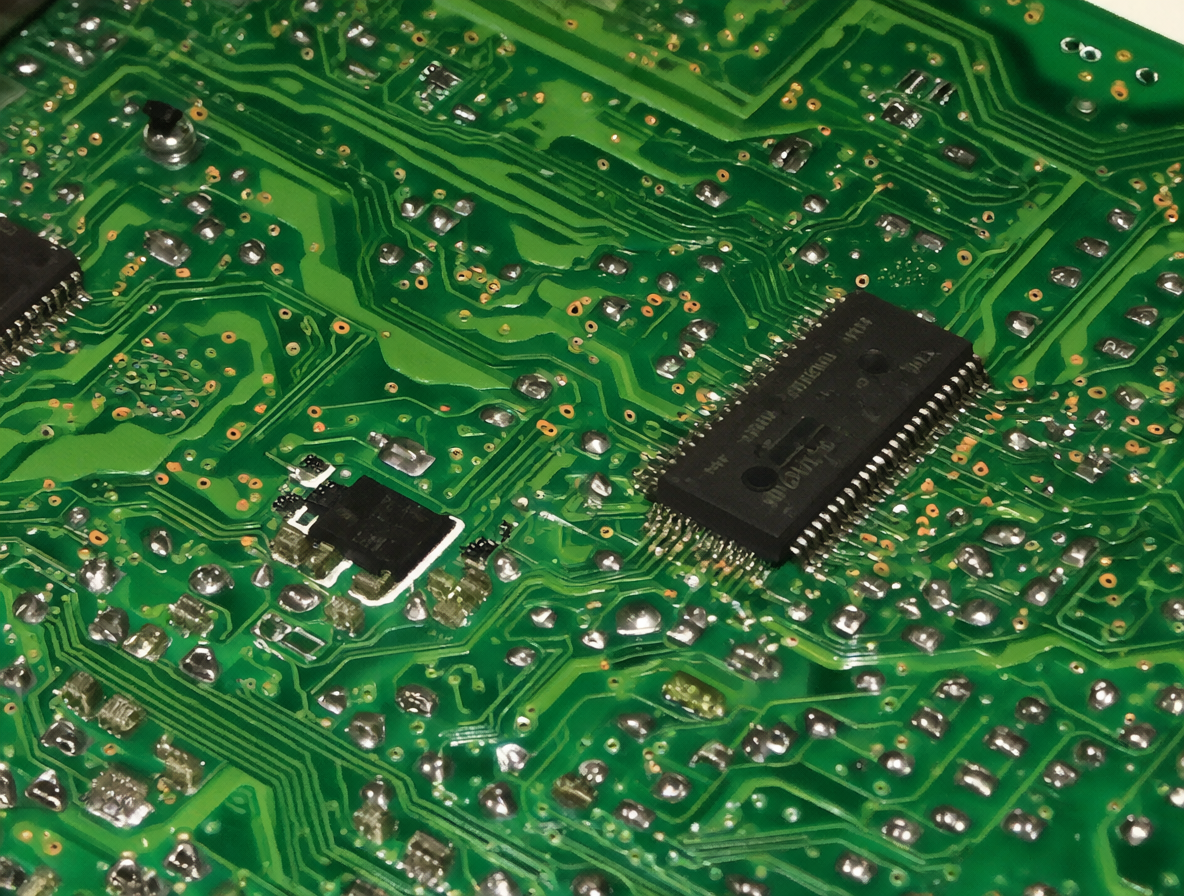 A detailed shot of an electronic T-CON board used in TV repair.