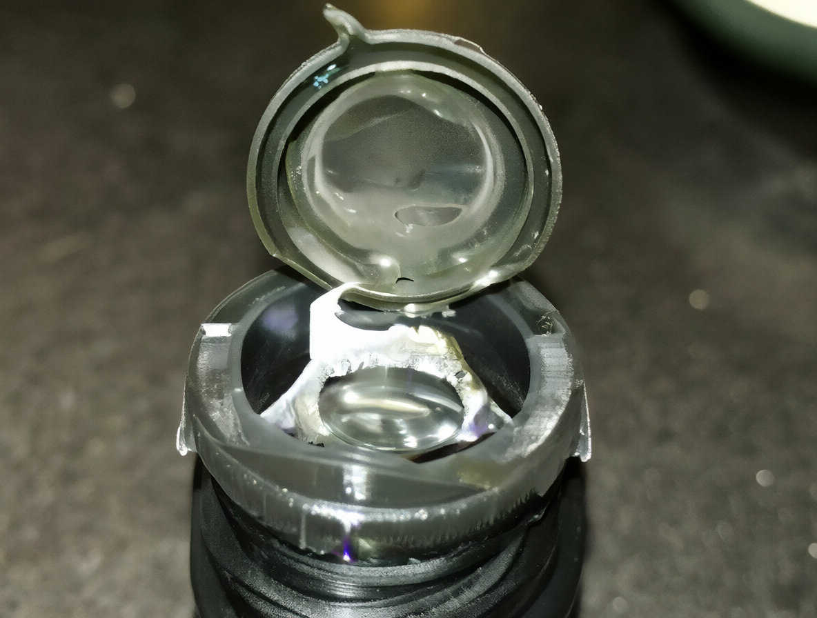 Close-up shot of an Epson ink bottle, focusing on the unscrewed cap and the nozzle area.