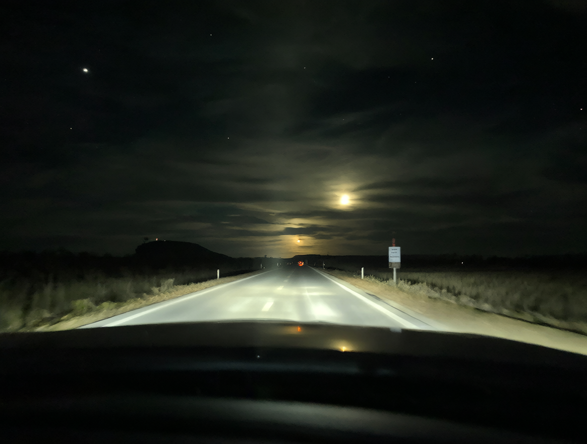 Un taxi vacío conduciendo por una carretera oscura bajo la luz de la luna, evocando el ambiente inquietante de las leyendas urbanas sobre conductores y pasajeros fantasma.
