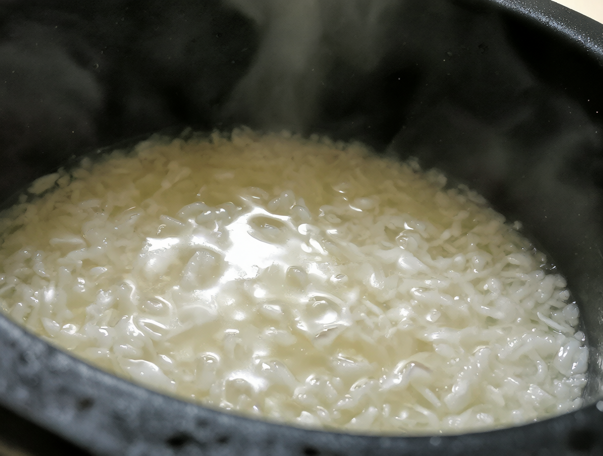 Olla de arroz con vapor saliendo del grano cocido