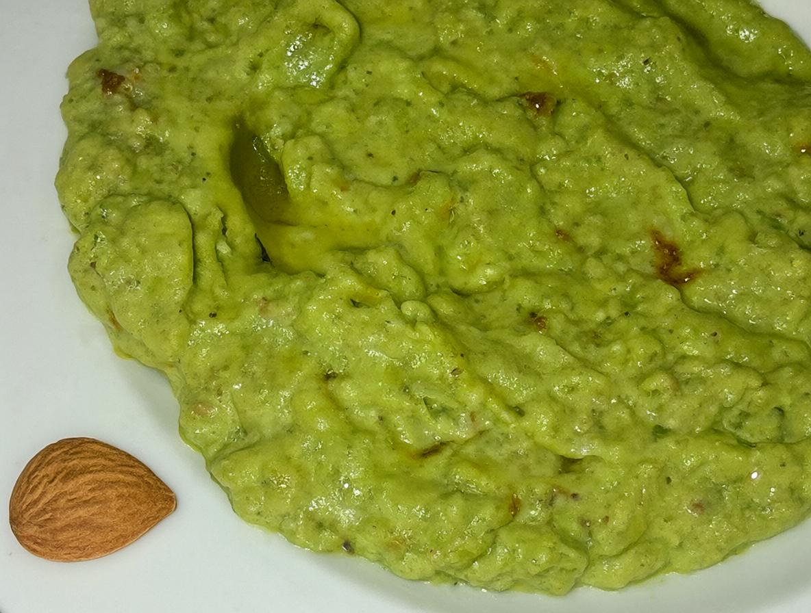 Plato de palta molida con una zona amarga resaltada y una almendra al lado
