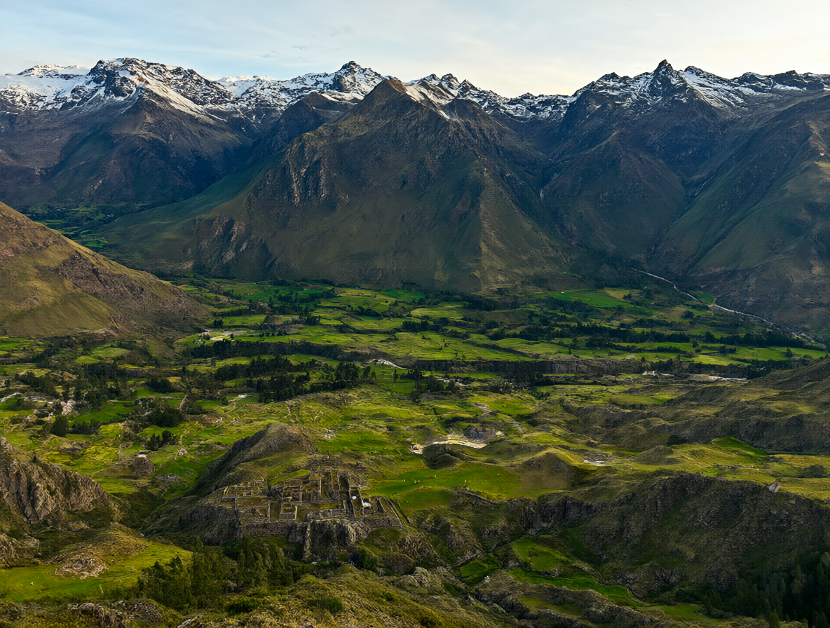 Vista aérea de las montañas de los Andes al amanecer con valles verdes y llamas pastando.