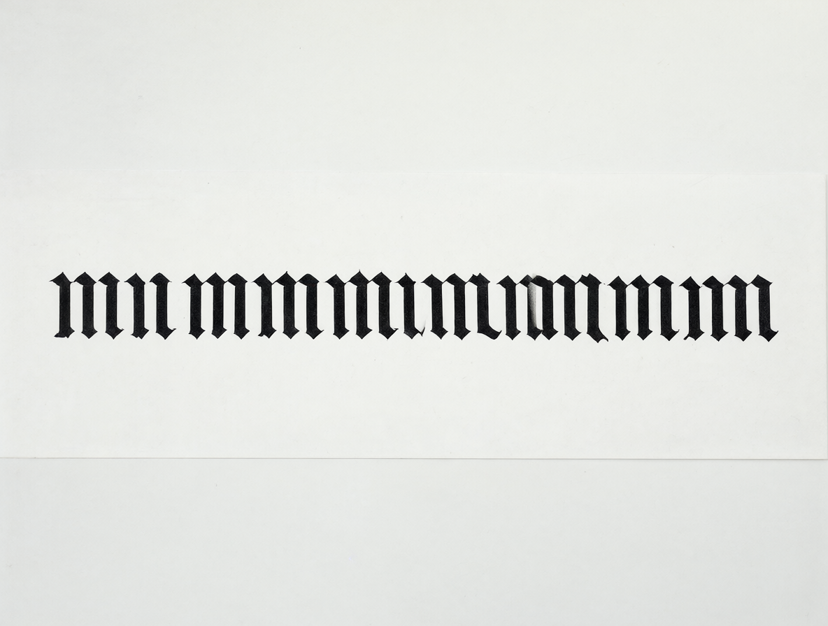 Texto negro sobre fondo blanco con la palabra mmmmmmmmmm escrita en tipografía gótica densa y espicada.