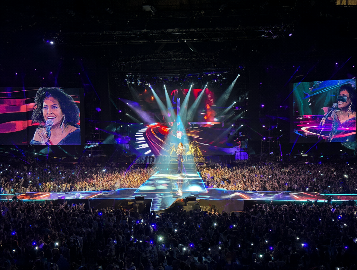 Ana Torroja del grupo Mecano cantando frente a una gran multitud con luces de escenario brillantes
