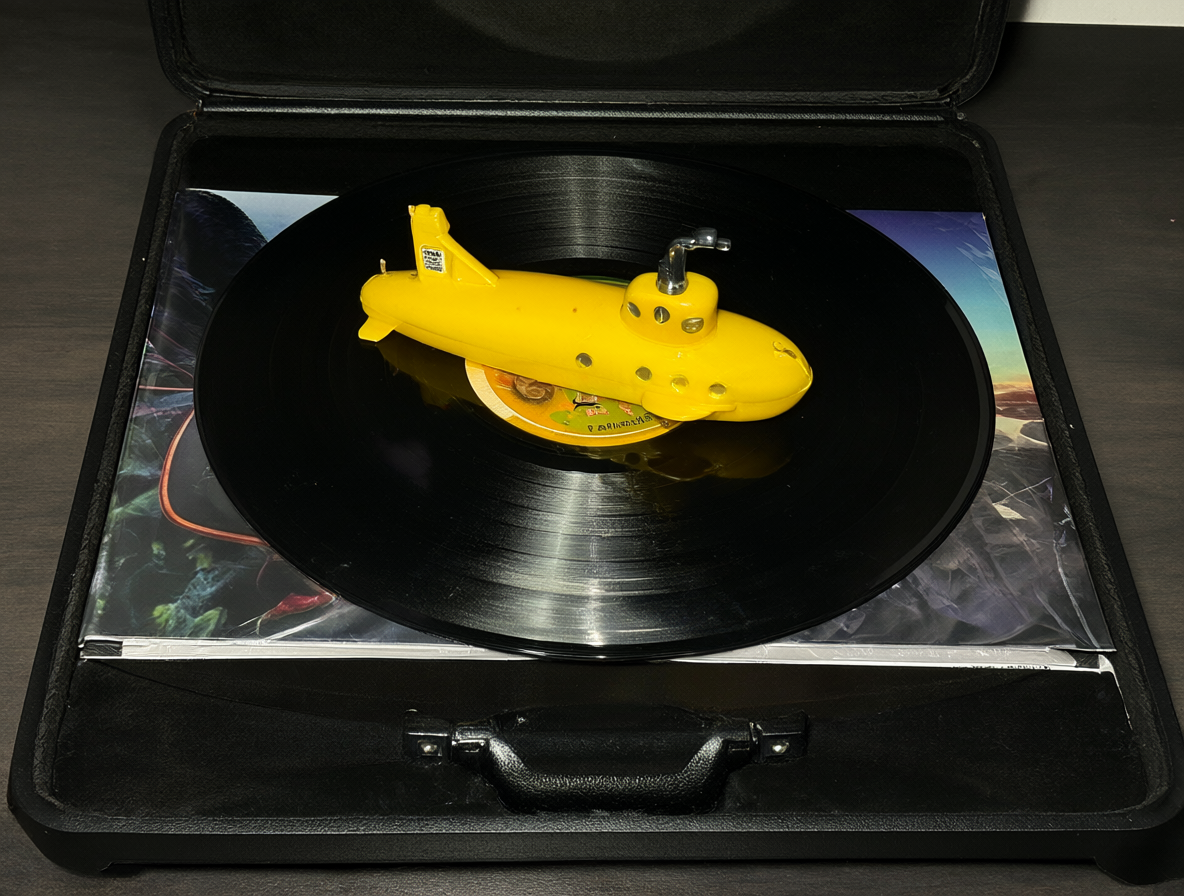 Caja de edición Super Deluxe abierta con varios discos y un submarino amarillo en primer plano