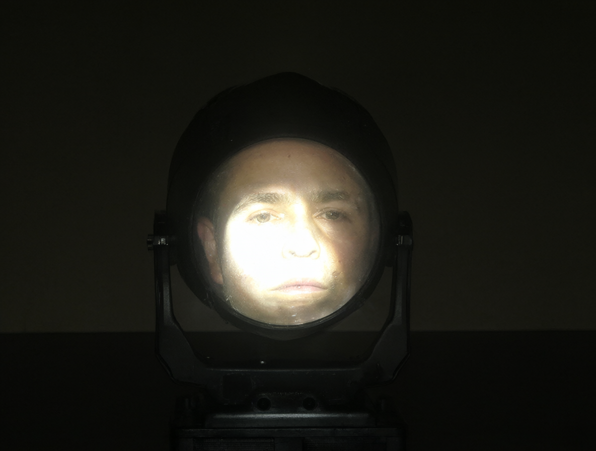 Foco PAR brillante apuntando a la cara del espectador en un salón oscuro.