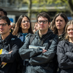 Grupos de personas en un espacio público mostrando actitudes contradictorias sobre su conocimiento.