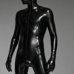 Retrato de un hombre con un traje de látex negro y reflectante que le cubre el cuerpo entero.