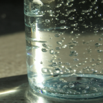 Botella de agua con gas clara y burbujeante.