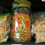 Estantería con snacks saludables como palomitas, verduras frescas y gelatina light.