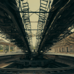 A wide view of a large railway turntable with one person nearby, highlighting its massive scale.