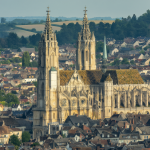 Vista panorámica de una gran catedral medieval dominando un pequeño pueblo europeo del siglo XII, mostrando el contraste entre la arquitectura monumental y el entorno modesto.