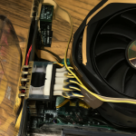 Un equipo de computación con una fuente Gigabyte P850GM y una GPU RTX 3090 sobre un escritorio de madera, iluminado por luz ambiental cálida junto a una ventana de acrílico transparente.