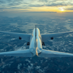 Un avión comercial sobrevolando el océano Atlántico con un atardecer de fondo