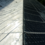 Imagen mostrando dos secciones: a la izquierda un techo blanco reflejando calor y a la derecha paneles oscuros absorbiendo energía.