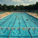 Vista general de una piscina con carriles y personas organizadas, destacando la desorientación del narrador en el centro del agua.