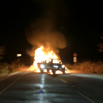 Patrulla policial ardiendo en un camino rural nocturno tras el atentado de Canete
