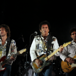 Foto de la banda de rock Soda Stereo actuando en un escenario.