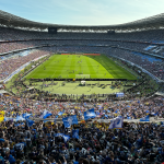 Grada repleta de fans en un estadio brillante durante la final del Mundial