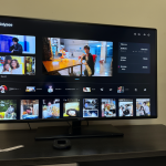 Televisor inteligente mostrando la interfaz de Odysee y un dispositivo Chromecast en una mesa de centro.