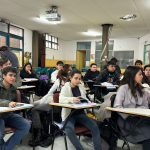 Estudiantes en un aula escolar interactuando sin usar dispositivos móviles