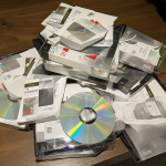 Varias cajas de software antiguo apiladas sobre una mesa de madera.