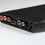 Foto de un dispositivo electrónico negro con puertos RCA y HDMI.