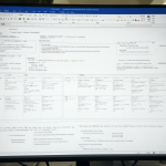 A computer monitor showing a confusing and messy Microsoft Word interface with embedded images instead of tables.