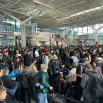 Viajeros esperando en filas numeradas para subir al avión.