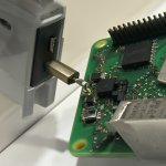 Raspberry Pi 3 conectada a un cargador USB y su cable micro-USB