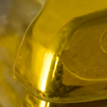 Un primer plano detallado de un lingote de oro brillante y rectangular sobre un fondo desenfocado.