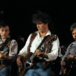 Foto de la banda Yes con el álbum 90125 y una guitarra destacada.