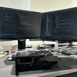 Foto de un escritorio con una tarjeta gráfica RTX 3090 y monitores mostrando código.