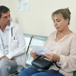 Mujer mayor revisando exámenes médicos en un consultorio